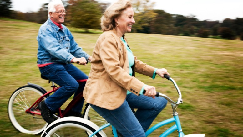 Senior man and woman resting after riding bicycles.